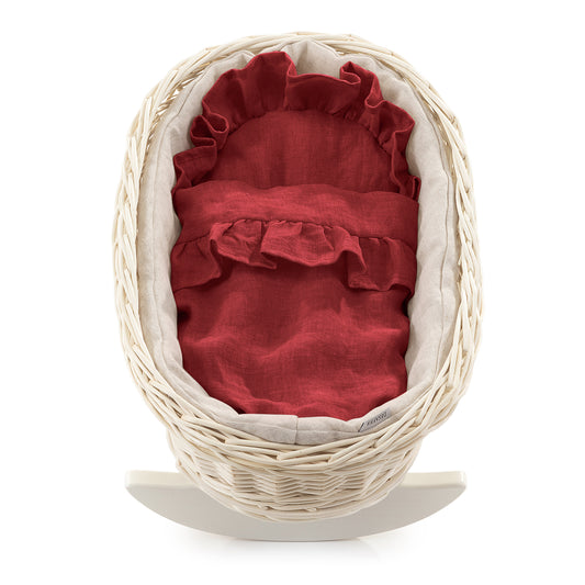 wicker doll cradle with red trim, with pillow and blanket