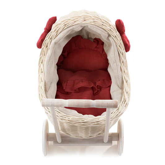 wicker doll stroller with linen trim and red bedding, featuring a handle, quilt, and pillow