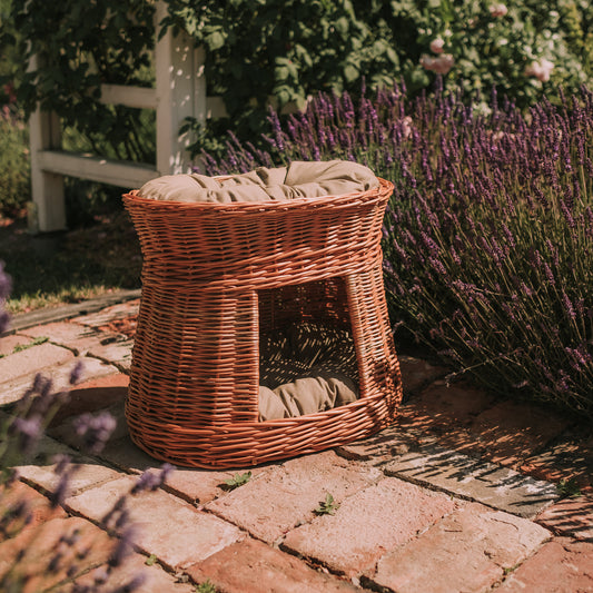 wicker cat house with two tiers and beige cushions