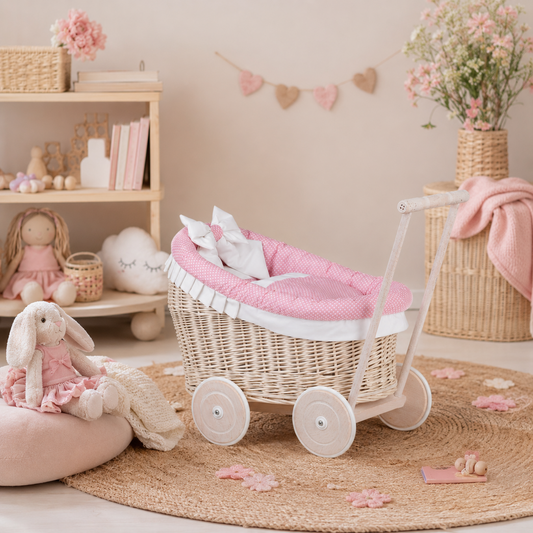 wicker doll stroller with pink trim, blanket and pillow