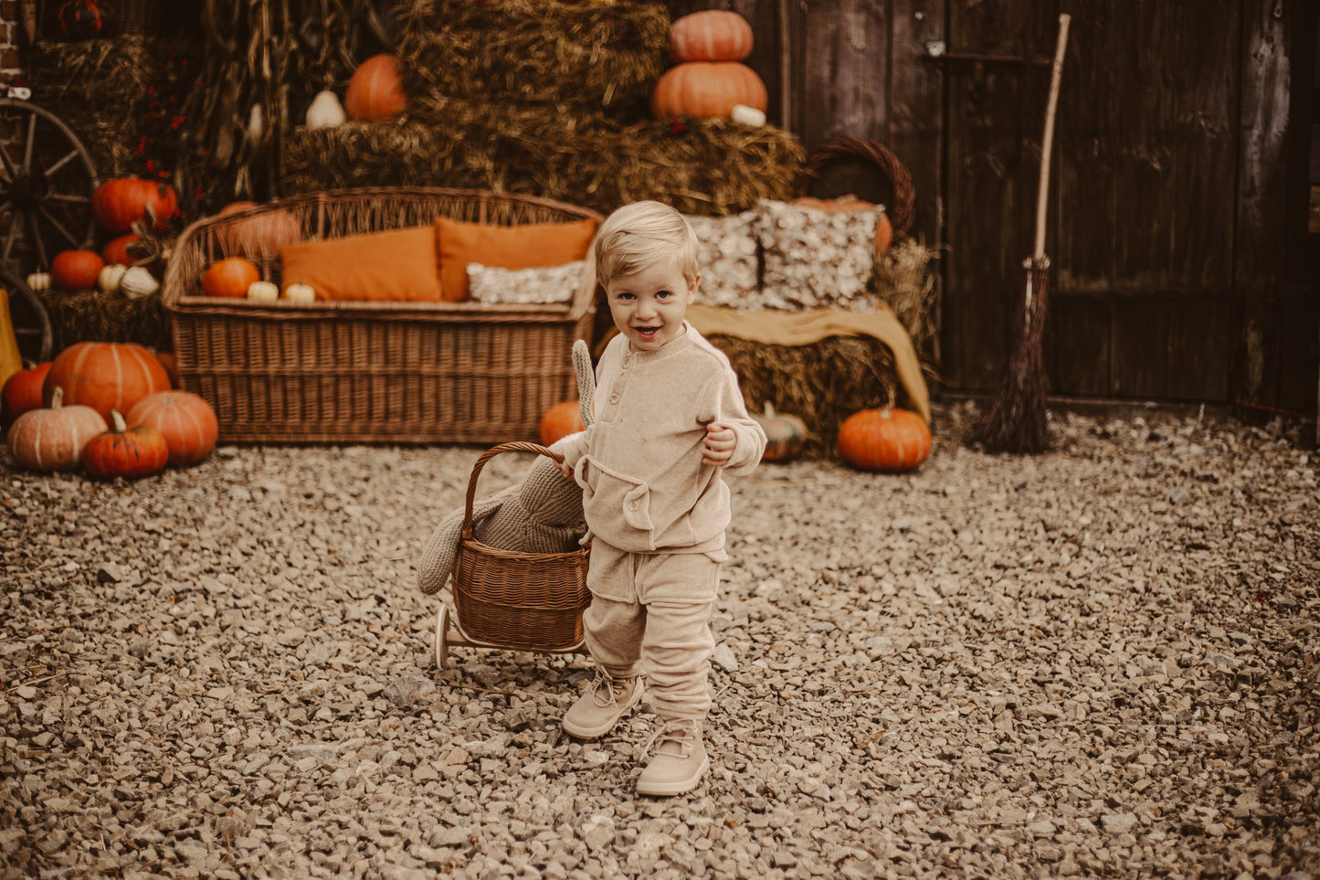 Luke wicker doll stroller with beige trim, handle, and wooden wheels TheWickerStories