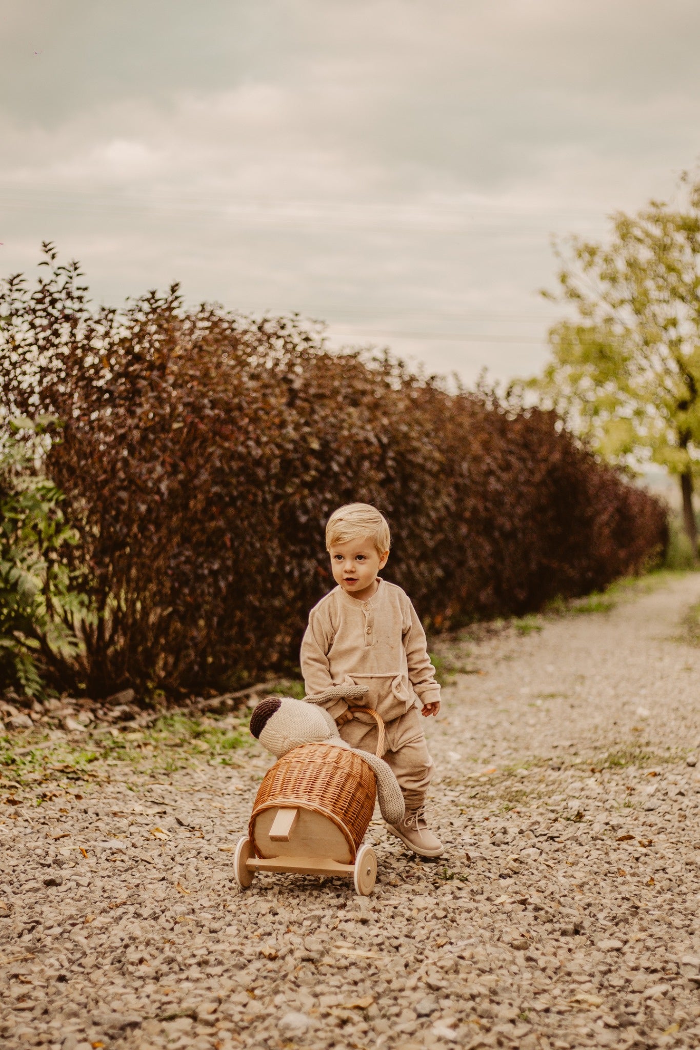 Luke wicker doll stroller with beige trim, handle, and wooden wheels TheWickerStories